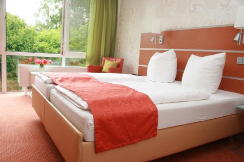ein Hotelzimmer mit einem Bett und einem Fenster in der Unterkunft Hotel-Restaurant Fasanerie in Marburg an der Lahn