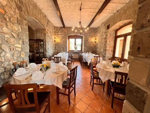 ein Esszimmer mit Tischen und Stühlen in einem Steingebäude in der Unterkunft Agriturismo Le Grottelle in SantʼAgata sui Due Golfi