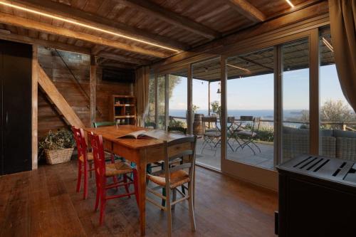 una sala da pranzo con tavolo e sedie in legno di Chalet Montecucco with lake view and jacuzzi a Gardone Riviera