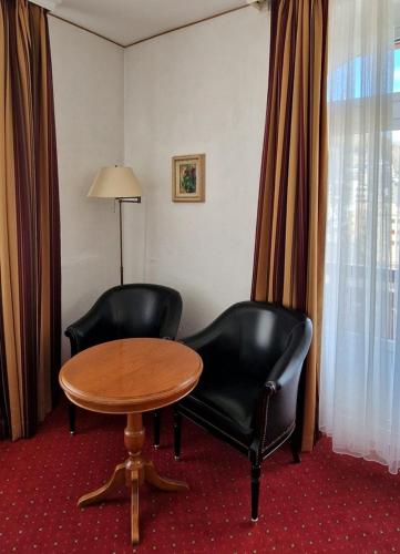 a room with two chairs and a table and a table at Soldanella in St. Moritz