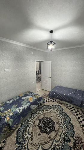 een slaapkamer met 2 bedden en een tapijt bij Avocado in Bisjkek