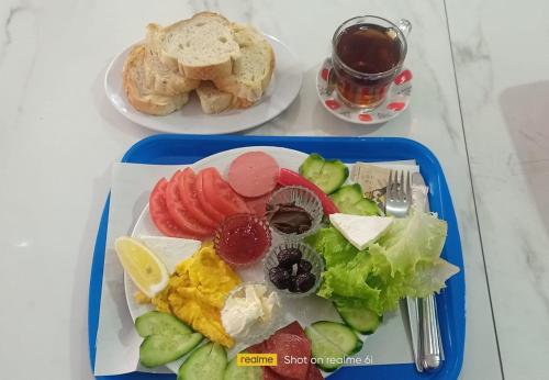 a blue tray with a plate of fruits and vegetables at TEKİNLER OTEL in Balıkesir