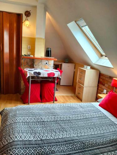 a bedroom with a bed and a table with red pillows at Zielone Wzgórze na Starówce in Sandomierz