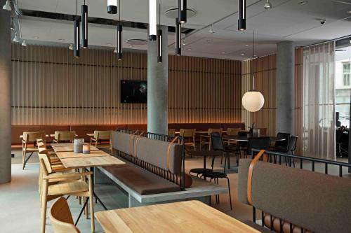 um restaurante com mesas e cadeiras de madeira e uma sala de jantar em Zleep Hotel Hillerød em Hillerød