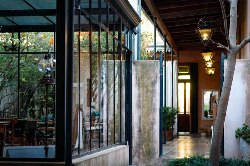 a restaurant with glass doors and a patio with tables at Antigua Casona Bed & Breakfast in San Antonio de Areco