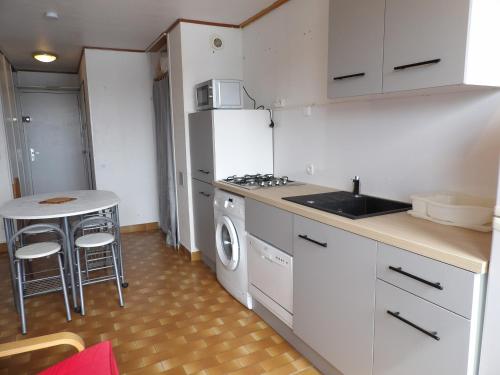 Il comprend une cuisine équipée d'une cuisinière, d'un évier et d'une table. dans l'établissement St cyprien appartement en residence avec piscine, à Saint-Cyprien