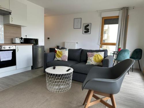 un salon avec un canapé et une table dans l'établissement Cosy 2 pièces et parking 30 mns Gare du Nord by immo kit bnb, à Villepinte