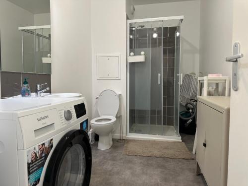 a bathroom with a toilet and a washing machine at Cosy 2 pièces et parking 30 mns Gare du Nord by immokitbnb in Villepinte