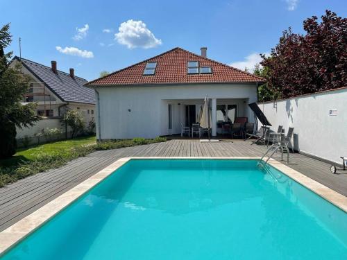 a swimming pool in front of a house at Freistehendes Ferienhaus mit Swimmingpool, Kamin, Internet, unweit Neusiedlersee in Fertőd