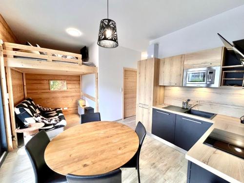 une cuisine et une salle à manger avec une table et des chaises en bois dans l'établissement Studio de 31m² idéalement situé aux pieds des remontées mécaniques été/hiver, à Saint-Gervais-les-Bains