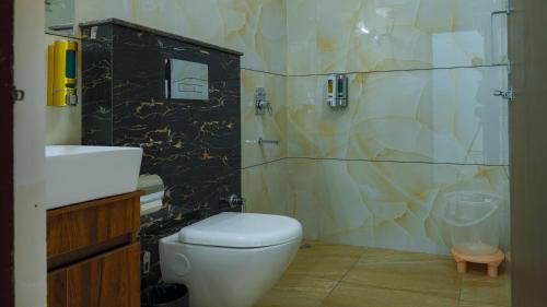 een badkamer met een toilet, een wastafel en een douche bij Hotel Spring Birds in Bhīm Tāl