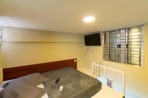 Dormitorio pequeño con cama y TV en 34 LOFT Duplo · LOFT 900m São Paulo Expo/ 300mts metrô Jabaquara, en São Paulo