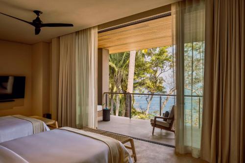 勒德馬可斯的住宿－One&Only Mandarina，一间卧室设有一张床和一个美景阳台