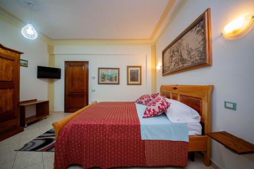 a bedroom with a bed with a red and blue blanket at Hotel "SAN SAENA " in Vlorë
