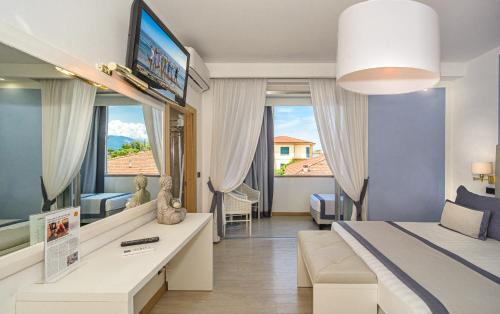 a hotel room with a bed and a tv at Raffaelli Park Hotel in Forte dei Marmi