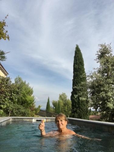 un homme dans une piscine qui lève le pouce dans l'établissement Gîte avec piscine Mes Vacances en Provence à Beaumes de Venise, à Beaumes-de-Venise