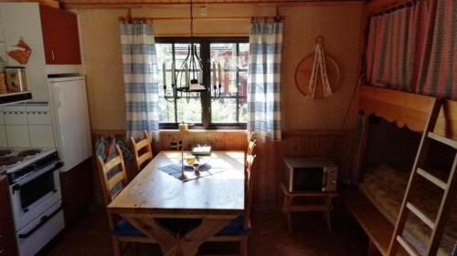 a kitchen with a wooden table in a tiny house at Kleines Ferienhaus auf Naturgrundstück in Seenähe - b48624 in Sollerön