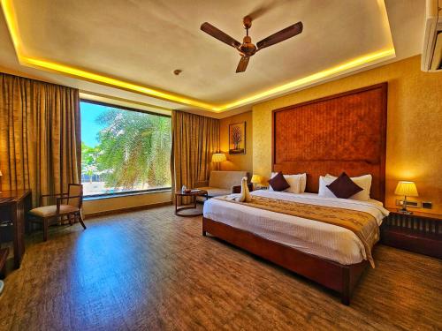 sypialnia z dużym łóżkiem i dużym oknem w obiekcie UVA Meridian Bay Resort & Spa w mieście Kundapur