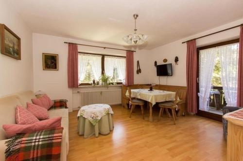 sala de estar con mesa y sofá en Ferienwohnung in Weißbach ADAlpenstraße - b57786 en Schneizlreuth