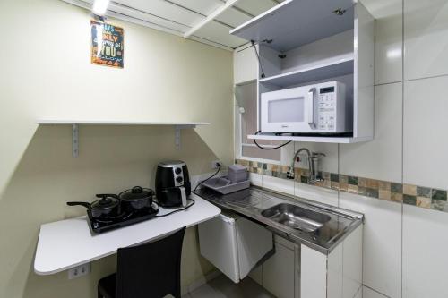 een kleine keuken met een wastafel en een magnetron bij 37 LOFT TRIPLO · Congonhas Airport, Jabaquara Metro, Expo São Paul in Sao Paulo