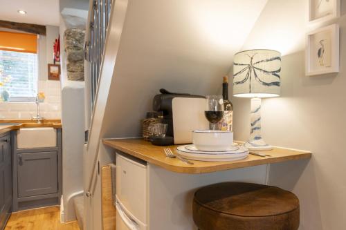 a small kitchen with a table with a lamp on it at Kitten Cottage 1 in West Witton