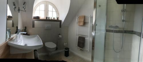 a white bathroom with a sink and a shower at Diekkieker in Tümlauer Koog