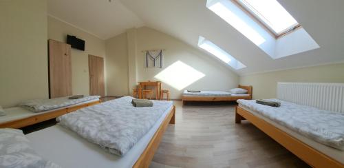 a attic room with three beds and a skylight at Pokoje Izabela - Noclegi Graboszyce - Zator in Graboszyce