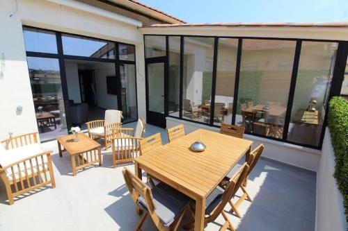 un patio avec une table et des chaises en bois dans l'établissement Unique appartement d'architecte, à Antibes