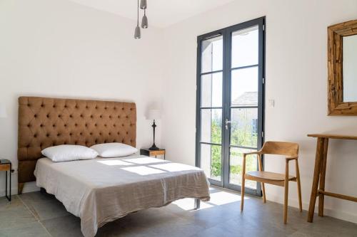 1 dormitorio con 1 cama grande y 1 silla en Belle villa vue mer- Erbalunga à 2 pas de la plage en Brando