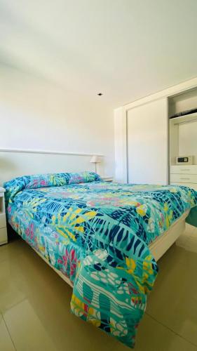 1 dormitorio con 1 cama con una manta colorida en TERRAZAS DE QUEQUEN en Quequén