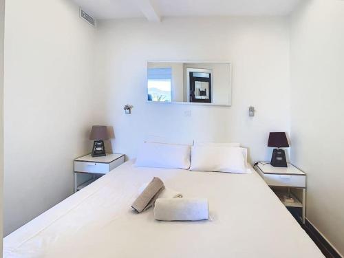 a bedroom with a large white bed with two lamps at Le Croisette I - 4 pers - Front de mer - Cannes in Cannes