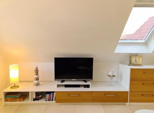 a living room with a flat screen tv on a counter at Ferienwohnung Grachtenhimmel in Greetsiel