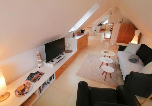 ein Wohnzimmer mit Sofa und TV in der Unterkunft Ferienwohnung Grachtenhimmel - a86189 in Greetsiel