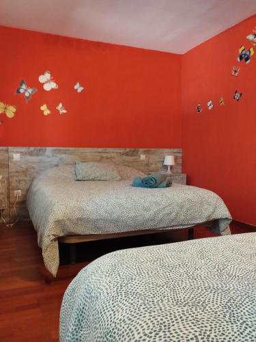 two beds in a room with red walls at Chalet con JARDIN PUY DU FOU a 10 min ,NO FIESTAS!! in Toledo