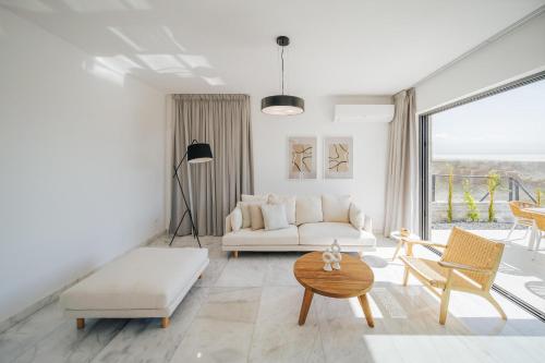 a living room with a white couch and a table at Oasis Villa 6 in Khlorakas