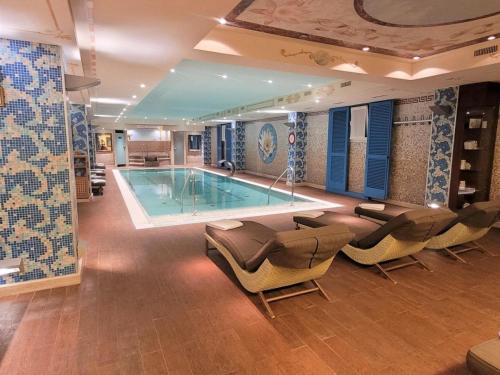una grande piscina in una stanza con sedie di A14Apt Rosa Blu a Brusino Arsizio