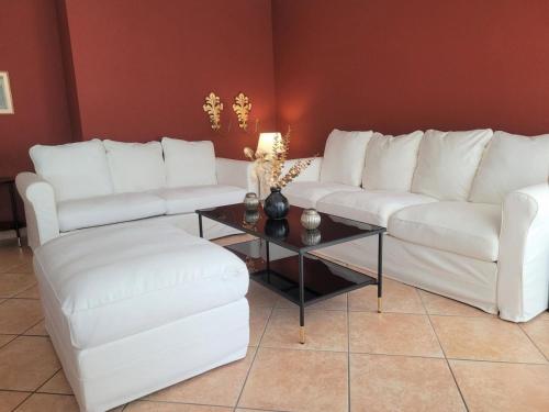 un soggiorno con divani bianchi e tavolino da caffè di A14Apt Rosa Blu a Brusino Arsizio
