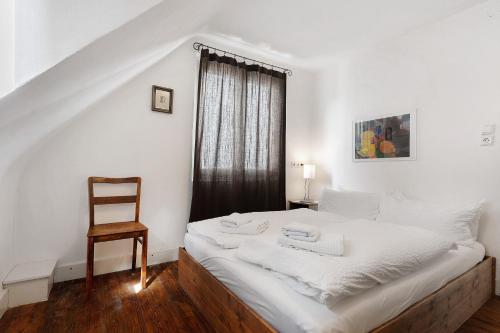 sypialnia z białym łóżkiem i krzesłem w obiekcie Ferienhaus am Künstleratelier w mieście Riegel