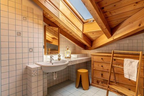 a bathroom with a sink and a wooden ceiling at Al Borgo, Taio Ospitar in Taio
