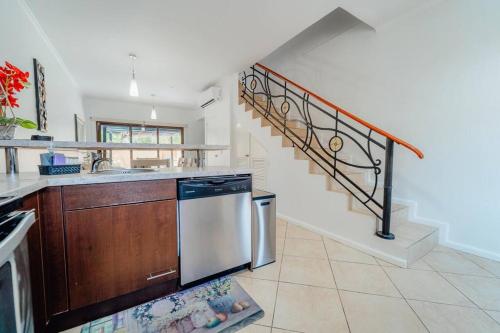 a kitchen with a dishwasher and a staircase at Gold coast beautiful house with private pool in Palm-Eagle Beach