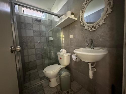 a bathroom with a toilet and a sink and a mirror at Casa de Campo Hotel Majestic Yurimaguas in Yurimaguas