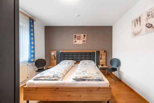 a bedroom with a bed with two chairs at Am Tivoli in Hermeskeil