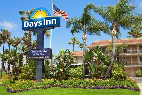 a sign in front of a hotel with palm trees at Days Inn by Wyndham San Diego Hotel Circle in San Diego