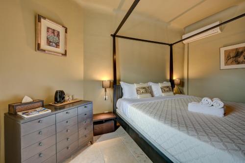 a bedroom with a bed and a dresser with towels at Hostellerie Le Paradou in Lourmarin