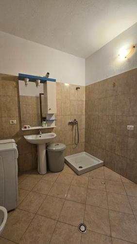 een badkamer met een wastafel, een douche en een toilet bij Big Apartment by the Adriatic Sea in Durrës
