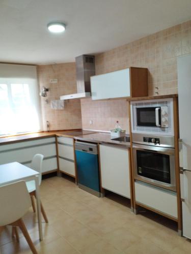 a kitchen with white appliances and a table in it at Chalet con JARDIN PUY DU FOU a 10 min ,NO FIESTAS!! in Toledo