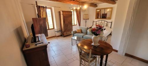 een woonkamer met een tafel en een bank bij Appartements de charme La Sarrazine in La Garde-Freinet