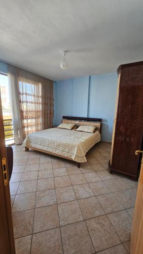 een slaapkamer met een bed en een tegelvloer bij Big Apartment by the Adriatic Sea in Durrës