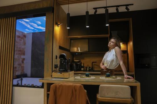 a woman standing in a kitchen with a glass of wine at Design Apartment PLATINIUM SPA LUX 5 STAR "HAVANA" Completely PRIVATE Wellness & Spa FREE INCLUDED Sauna & Jacuzzi & Salt Wall & Fire place & 3D Ceilings & Business WiFi & NETFLIX & Keyless code entry & FULL SMART APP & SECURE 2 Parking place in Ćuprija