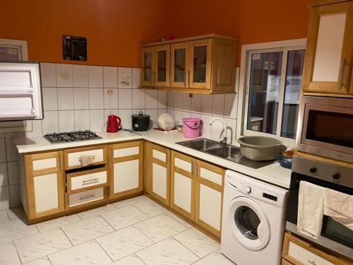 een keuken met een wastafel en een wasmachine bij Appartement T3 Bandrélé in Bandrélé